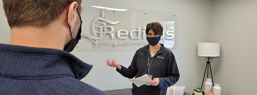 Halley holds a stand-up meeting with a Reditus staff member. Photo by Paul Swiech