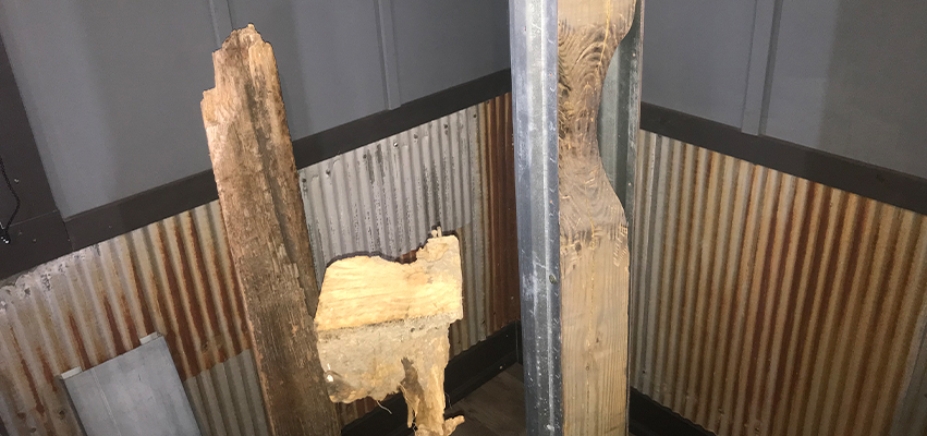 Rotted wooden posts (left) are shown next to a post reinforced with a column repair sleeve, a patented product at Savage Building Systems in Varna