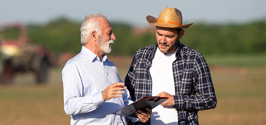 And older and younger man in a field