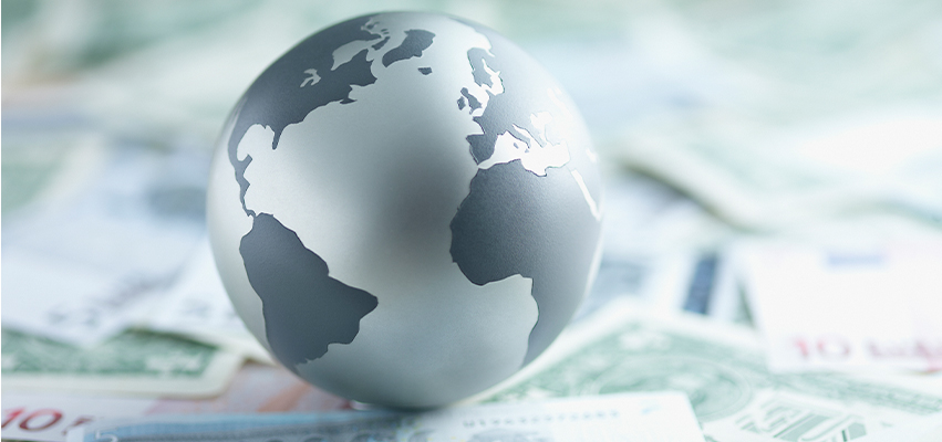 A Silver Globe sitting on Currency